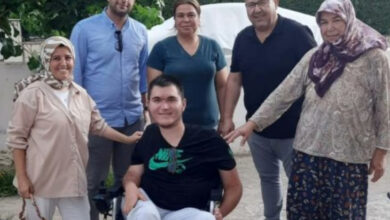 Menderes Belediye Başkanı İlkay Çiçek, engelli birey ve ailesi birlikte akülü tekerlekli sandalye hediyesi verildikten sonra fotoğraf çekiliyor.