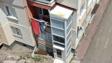 Bir apartmanın dışına yapılmış engelli asansörü fotoğrafta var.