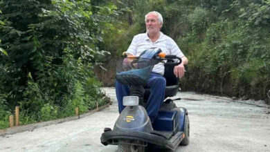 Üç tekerlekli akülü engelli aracıyla yeni yapılan yolda Mustafa Akdeniz geziyor.