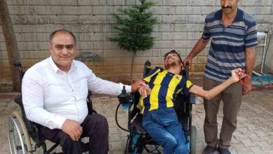 Engelli birey Tayfun Yazar akülü tekerlekli sandalye üzerinde oturuyor, babası sağında, Türkiye Sakatlar Derneği Elazığ Şube Başkanı Metin Fırat tekerlekli sandalye üzerinde fotoğrafın solunda yer alıyor.