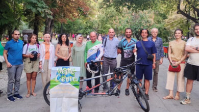 Eşpedal Derneği'nin düzenlediği etkinlikte tandem bisikletin arkasında katılımcılar ayakta yan yana durarak fotoğraf çekiliyor.