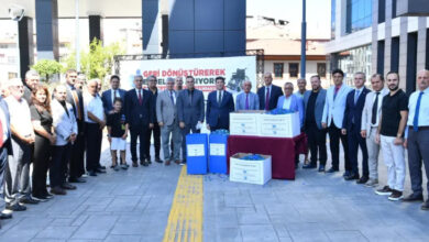 Ortahisar Belediye Başkanı Ahmet Kaya ve belediye personelleri proje kapsamında toplu fotoğraf çekiminde ayakta hilal biçiminde yan yana duruyorlar.