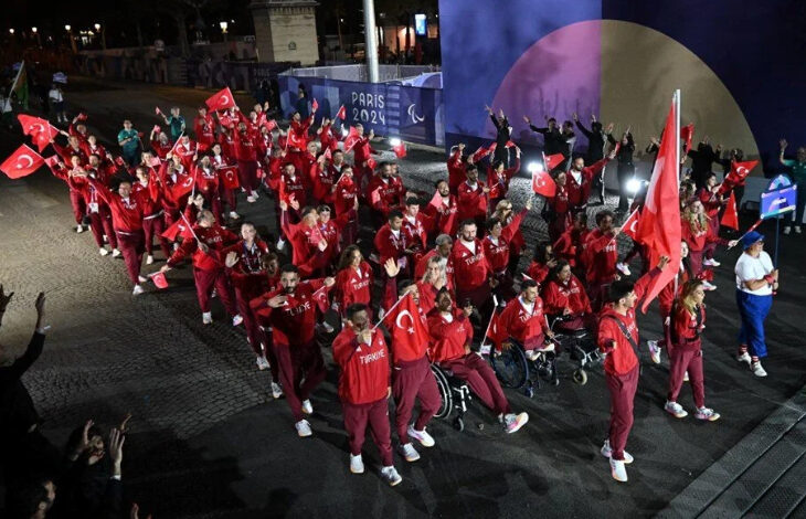 Fotoğrafta, Türk Milli Paralimpik Sporcuları açılış töreninde Türk bayrağını taşıyor. Aynı zamanda paralimpik sporcuların üzerinde Milli Takım forması var.