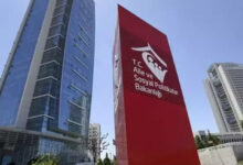 Fotoğrafta, bir gökdelenin yanında kırmızı renkli dikey bir tabela var. Tabelanın üzerinde “T.C. Aile ve Sosyal Hizmetler Bakanlığı” yazıyor.