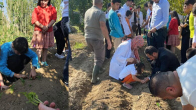 Engelli öğrenciler, sera alanında toprağa fide ekiyorlar.