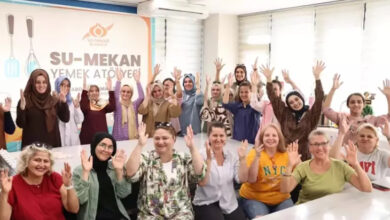 Atölyeye katılan işitme engelli bireyler, ellerini yukarı doğru kaldırarak işitme dilindeki alkış hareketini yapıyorlar.