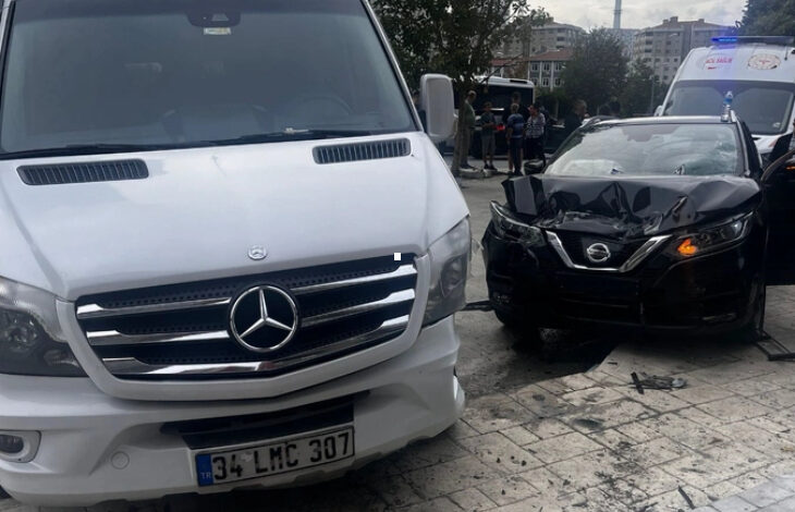 Beyaz bir minibüs ve siyah bir otomobil ön taraftan birbirleriyle çarpışmışlar. Siyah otomobilin ön tarafı içeriye doğru girmiş ve kaput kapağı kırılmış.