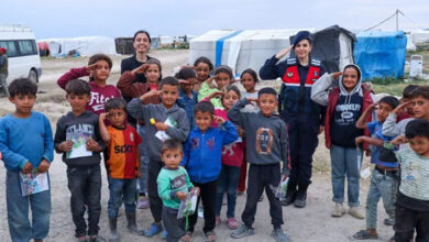 Jandarma komutanının etrafına toplanmış olan çocuklar asker selamı veriyor.