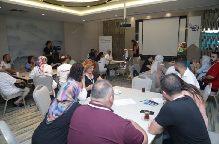 SMA’lı bireylerin aileleri birkaç farklı yuvarlak masa etrafında oturarak etkinlik kapsamında proje geliştirme eğitimi alıyorlar.