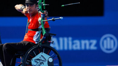 Tekerlekli sandalye kullanıcısı Milli Paralimpik Okçu Bahattin Hekimoğlu, bir eliyle yayını tutup, diğer eliyle ise oku- yay üzerine çekip fırlatmış.