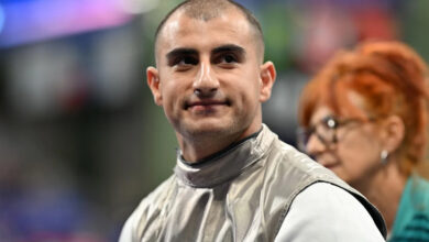 Tekerlekli sandalye eskrimde milli sporcu Hakan Akkaya, başı fotoğrafa göre sağa doğru dönük olarak bir yere doğru bakıyor ve yüzünde hafif bir tebessüm var.