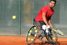 Tekerlekli sandalye tenis quad kategorisinde milli sporcu Ahmet Kaplan, elindeki tenis raketi ile topa vuruş yaptıktan sonra çekilmiş bir fotoğraf.