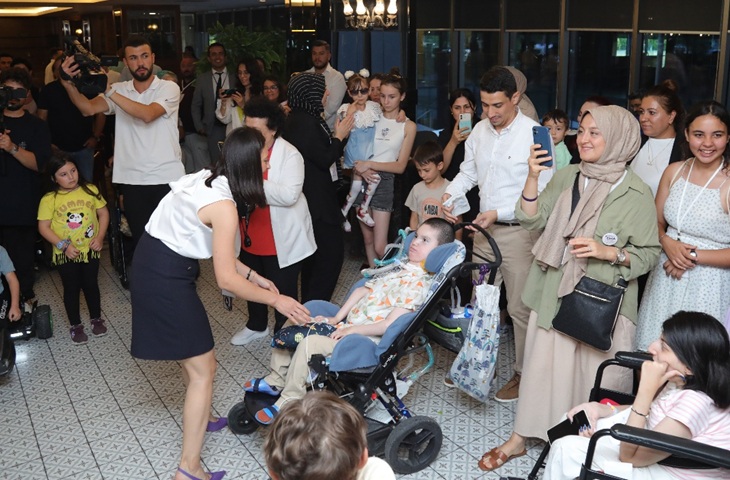 Fotoğrafta, SMA’lı çocuklar ve aileleri dans ediyor.