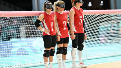 Golbol Kadın Milli Takımı sporcuları, ayakta ve yan yana durarak 3 sporcu birbirinin elini tutuyor.