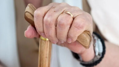 Parmağındaki yüzüğü takılışından fotoğraftaki kişinin bir kadın olduğu anlaşılıyor. Fotoğraftaki kadın tahta bir bastonu üstünden ve alt tarafından tutarak destek alıyor.