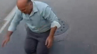 Engelli bireyin babası otobüsün önüne dizüstü çökmüş ve otobüsün geçişini engelliyor.