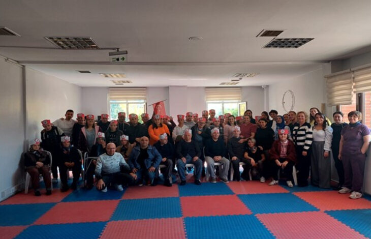 Eskişehir Büyükşehir Belediyesi Zihinsel Engelli Gündüz Yaşam Merkezinde düzenlenen Cumhuriyet Bayramı etkinliğinde çekilen bir toplu fotoğrafta engelli bireyler yan yana duruyorlar.