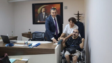 Fiziksel engelli M. Emre Öncel, Dalama Kaymakamı Mesut Yakuta’ya makam odasında yazmış olduğu kitabı masanın üzerine annesinin desteği ile katarak imzalıyor.