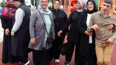 Fotoğrafın arka planında yer alan salıncak ve tahterevalli gibi oyun alanları nedeniyle bir çocuk parkı olduğunu bize anlatıyor. Fotoğrafın ön tarafında ise 2 engelli birey ve 5 engelli yakını olan kişiler fotoğraf çekilmek için bir araya gelmişler.