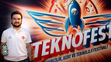 Selçuk Üniversitesi öğrencisi Muhammet Hakan Kırca, Elinde tuttuğu telefon ile bir uygulamayı gösteriyor ve arkasında “Teknofest”, altında ise “Havacılık, Uzay ve Teknoloji Festivali” yazısı olan bir tabela var.