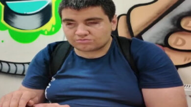 Görme engelli birey İbrahim Koyulmuş, röportaj için graffiti yapılmış bir duvarın önünde oturuyor ve soruları yanıtlıyor.