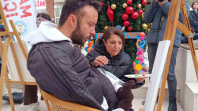 Milli Paralimpik Yüzme Sporcusu Sefa Yurtkölesi, ayaklarıyla tutmuş olduğu resim fırçasını kullanarak tuval üzerinde resim yapıyor.