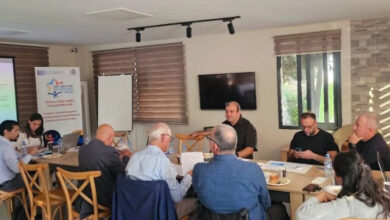 Fotoğrafta, bir masa etrafında toplanmış engelli bireyler ve projenin yürütücüleri oturuyor.