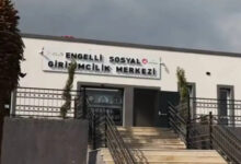 Fotoğrafta, "Engelli Sosyal Girişimcilik Merkezi" yazılı bir tabelanın asılı olduğu bina var. Binanın girişinde birçok merdiven olduğu görülmektedir.