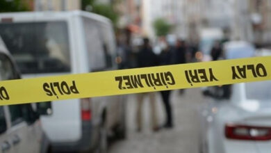 Fotoğrafta, caddenin arka tarafı puslandırılmış ve yolun ortasında uzun bir sarı şerit var. Sarı şerit üzerinde “Polis”, “Olay Yeri İnceleme” yazıları olduğu görülmektedir.