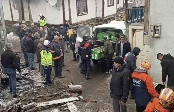 Fotoğrafta, cenaze nakil arabasına tabut içinde ölen kişinin naaşı yükleniyor. Arabanın çevresinde polis, AFAD ekipleri ve itfaiye ekipleri var.