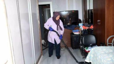 Fotoğrafta, Kepez Belediyesi'nin evde sağlık hizmeti ekibinin temizlik konusunda da destek olduğu görülüyor. Görevlinin elinde elektrikli süpürge ile evi süpürüyor.