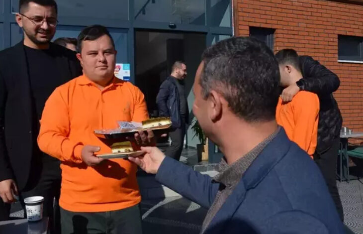 Fotoğrafta, down sendromlu bireyler istihdam edildikleri kafede gelen konuklara yiyecek ve içecek servisi yapıyorlar.