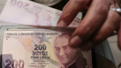 Para sayma makinesinin içinde 200 TL'lik banknotlar var. Bir kişi bu paraları eliyle makinenin içine katmış.