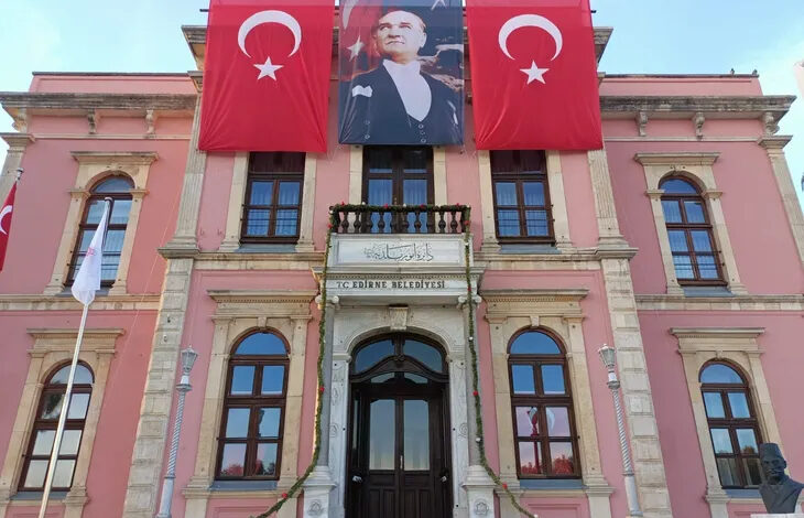 Edirne Belediyesi binasının dışarıdan çekilmiş bir fotoğrafı var. Fotoğraf aşağıdan yukarıya doğru bakılacak bir açıyla çekilmiş. Binanın en üst bölümünde iki Türk bayrağının arasında Mustafa Kemal Atatürk'ün bir posteri var.