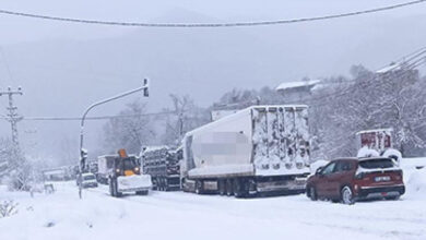 Fotoğrafta, karla kaplı bir yolda birçok otomobilin hareket edemeden durduğu görülmektedir.