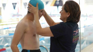 Fotoğrafta, havuzun kenarında yüzme sporcusu engelli birey Enes Emin Şener'in başına annesi yüzme bonesini takıyor.