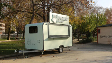 Fotoğrafta, beyaz renkli üzerinde Engelsiz Kafe yazısı olan bir karavan var.