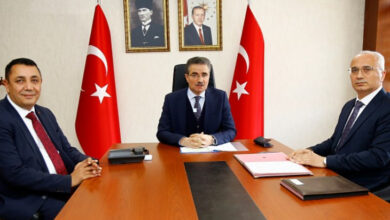 Fotoğrafta, Vali Aydın Baruş, Belediye Başkanı Vedat Soner Başer ve Aile ve Sosyal Hizmetler İl Müdürü Dr. Cengiz Maden bir masanın etrafında oturuyor ve önlerindeki protokolü imzalıyorlar.