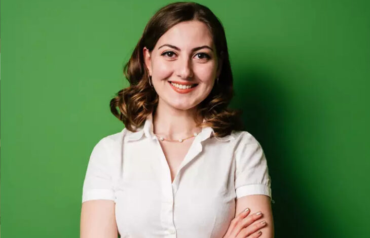 Yeşil renkli bir arka planı önünde duran sosyal girişimci Sibel Kaya var.