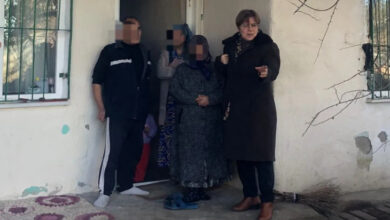 Kırıkkale Belediyesi Sosyal Yardım Merkezi Başkanı İlknur Ataklı, bir evin önünde engelli birey ve ailesinin yanında duruyor.