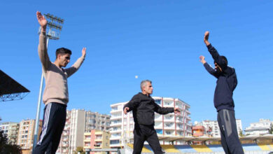 Görme engelli genç sporcular Reşit ve Aydın İmaç, antrenörleri ile birlikte ısınmak için bazı egzersiz hareketlerini yapıyorlar.