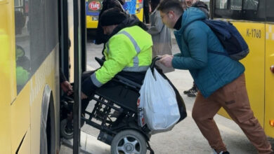 Akülü tekerlekli sandalye kullanan engelli birey, Büyükşehir Belediyesi'ne ait otobüse rampayı kullanarak binmeye çalışıyor. Ancak rampa çok dik olduğu için akülü tekerlekli sandalyenin arkasından bir kişi itekliyor.