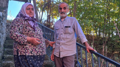 Fotoğrafta yer alan dik birçok basamağın olduğu evin girişinde Demirci ailesi ayakta duruyor.