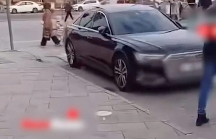 Fotoğrafta yer alan siyah bir otomobil engelli rampasının iniş alanına park ederek tekerlek ve sandalye veya akülü tekerlekli sandalye geçişini engelliyor.