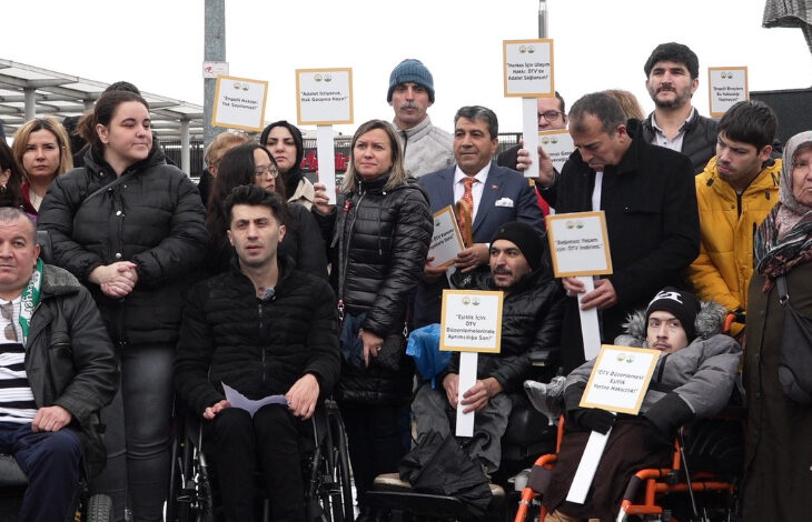 Osmangazi Kent Konseyi Engelliler Meclisi, bir meydan gibi yerde basın açıklaması yapıyorlar. Engelli bireyler ve aileleri basın açıklamasına yoğun katılım göstermişler.