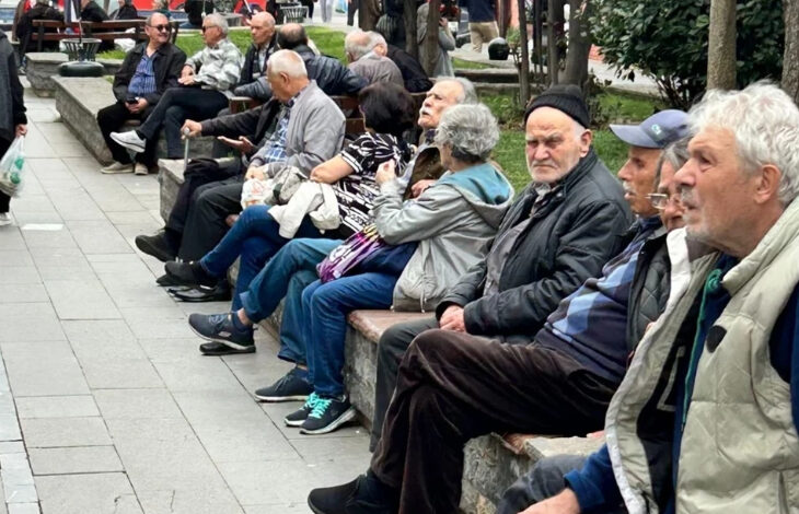 Fotoğrafta, bir parkta yan yana oturan yaşlı bireyler var. Yaşlı bireyler parkta oturarak zaman geçiriyor.