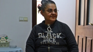 Fotoğrafta, yeni evinde oturma odasında tekerlekli sandalyede oturan Emel Örün var.