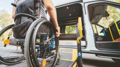 Tekerlekli sandalye kullanan engelli birey, özel bir asansör desteği ile arabanın içerisine biniyor.