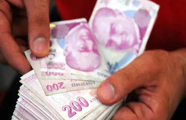 Görsel, bir kişinin elinde 200 TL banknotlardan oluşan bir deste tuttuğunu gösteriyor.