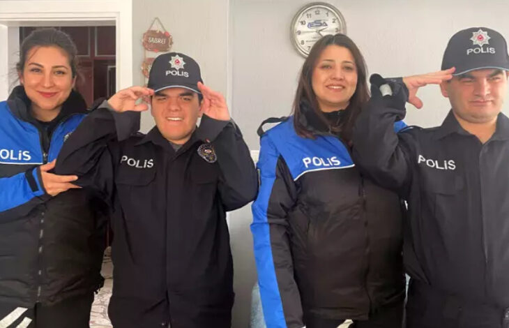 Görselde, iki genç erkek ve iki kadın polis memuru birlikte poz veriyor. Gençler, polis üniforması giymiş ve şapka takmış, gururla selam veriyorlar. Kadın polis memurları ise onlarla birlikte gülümseyerek poz veriyor. Arka planda duvarda bir saat ve “Sabır” yazılı küçük bir dekor bulunuyor.